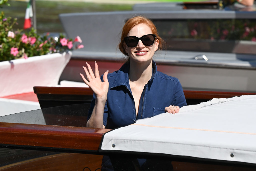 Closeup of Jessica Chastain waving as she stands on a boat