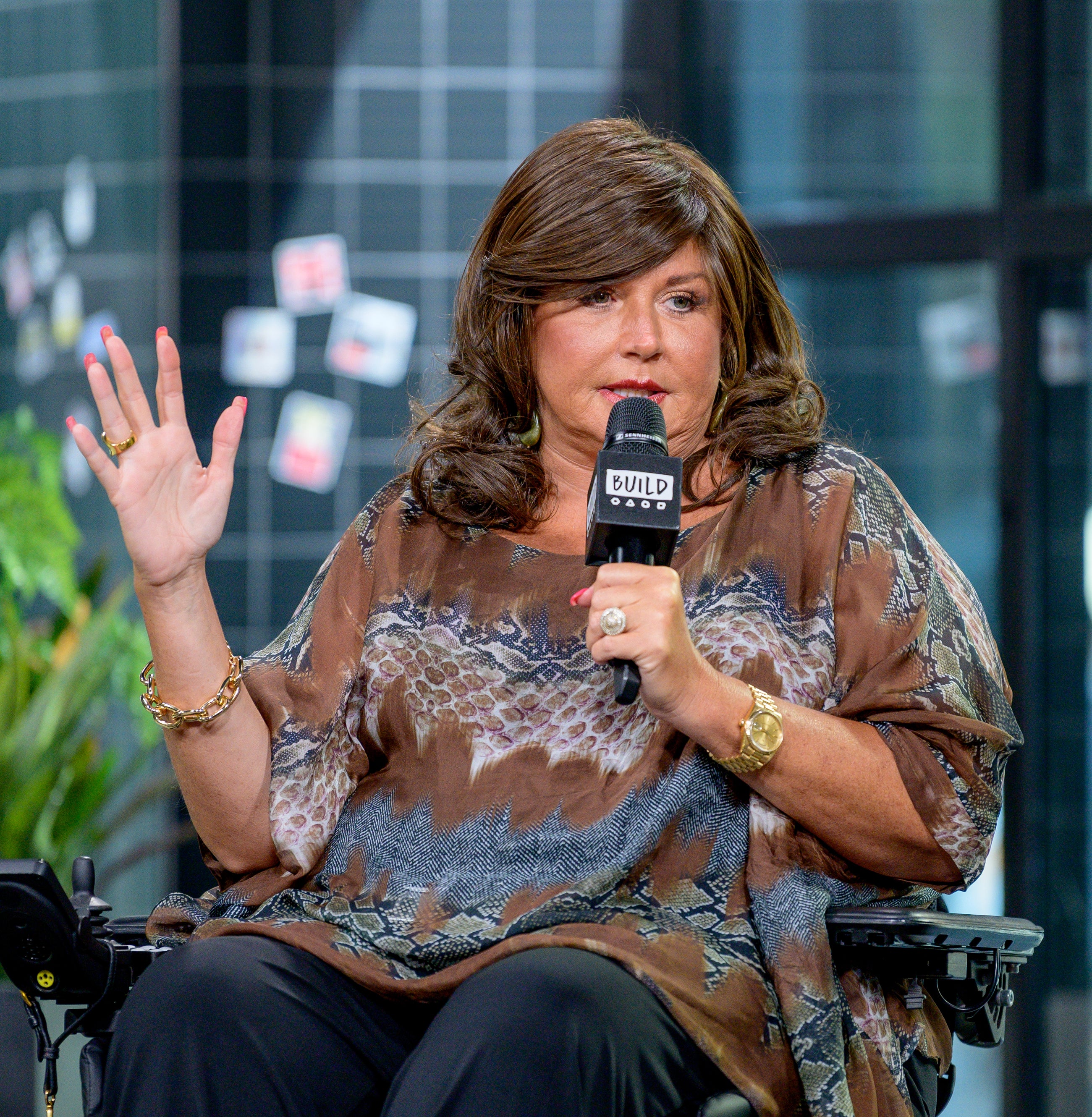 Abby seated and speaking into a microphone