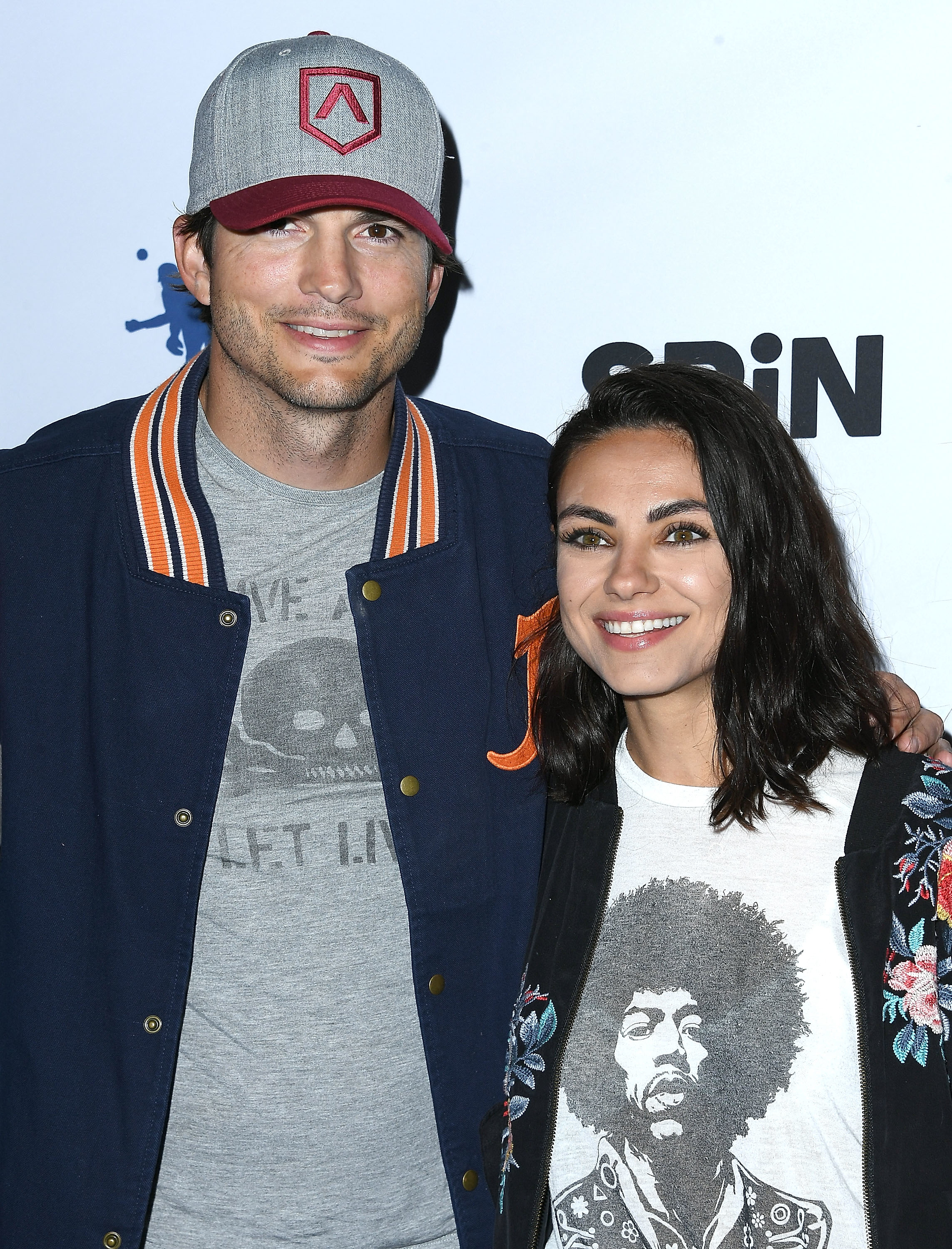 Ashton and Mila smiling at a media event