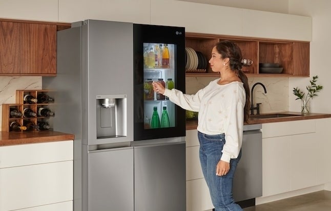 model in front of the fridge with a glass panel