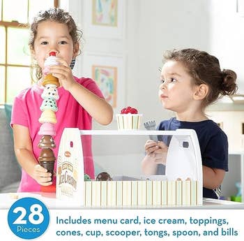 Two kids playing with the ice cream station