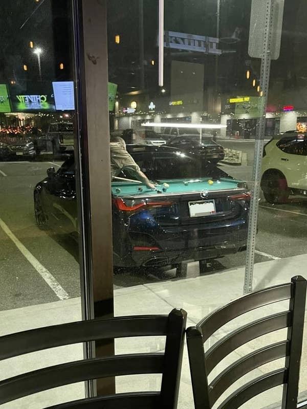 reflection from the window makes it look like there's a pool table on the back of a car