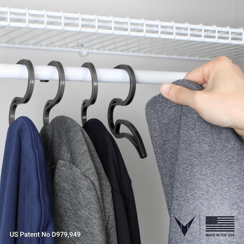 four hoodie hangers installed on a closet rod with sweatshirts hanging from each
