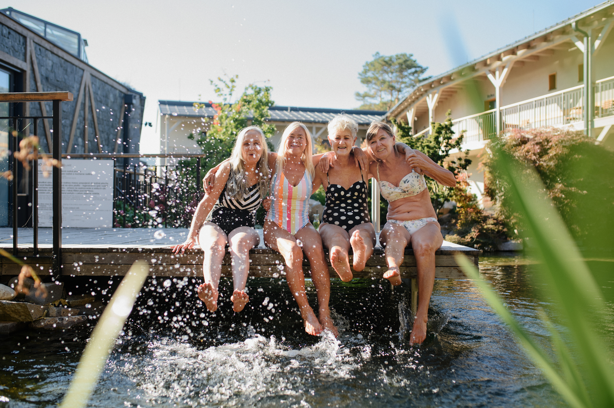 A friend group of older women are hanging out by the water