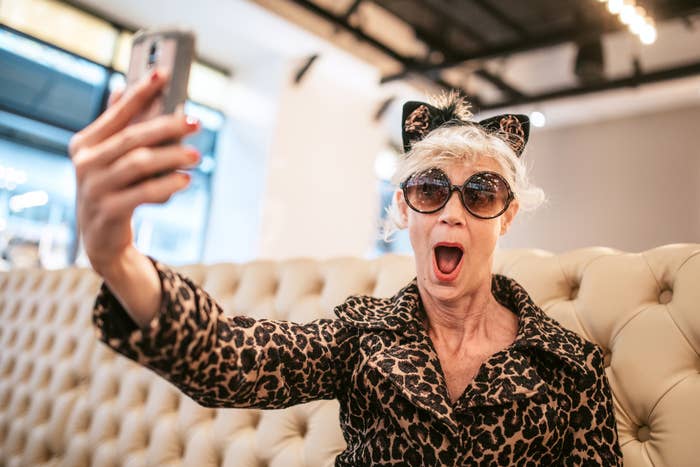An older woman is taking a selfie to show off her cheetah-inspired outfit