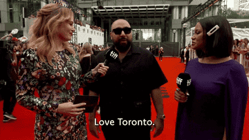 Two women interview a man wearing sunglasses on the red carpet who says &quot;Love Toronto.&quot;