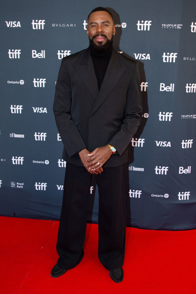 Colmon Domingo poses on the TIFF red carpet in a suit and turtleneck.
