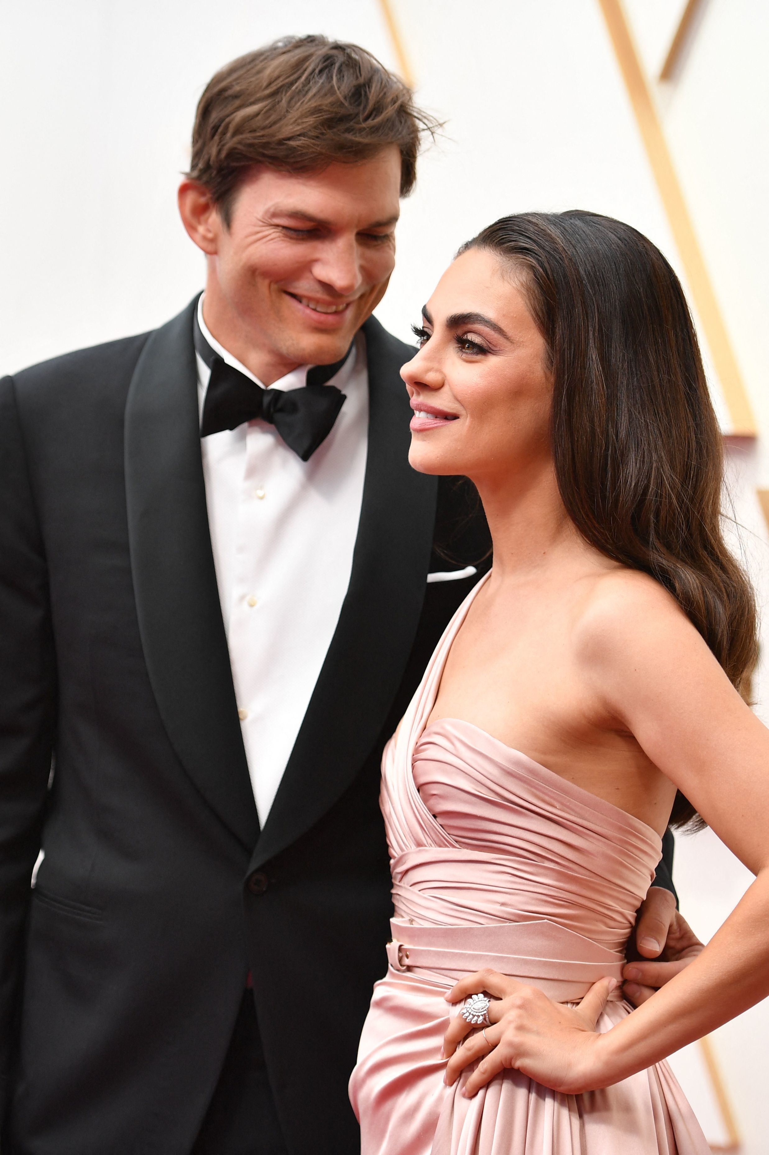 Ashton Kutcher looking lovingly at his wife Mila as the stand on the Oscars red carpet