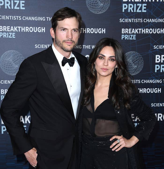 Ashton and Mila standing for a photo on the red carpet of a media event