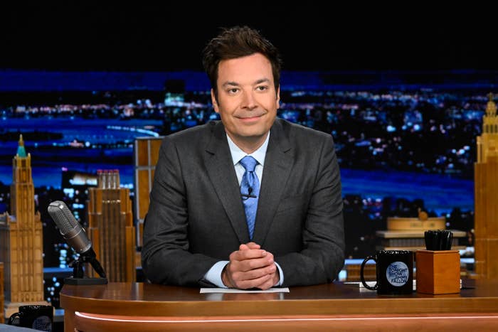 Closeup of Jimmy Fallon sitting at his desk on the set of The Tonight Show