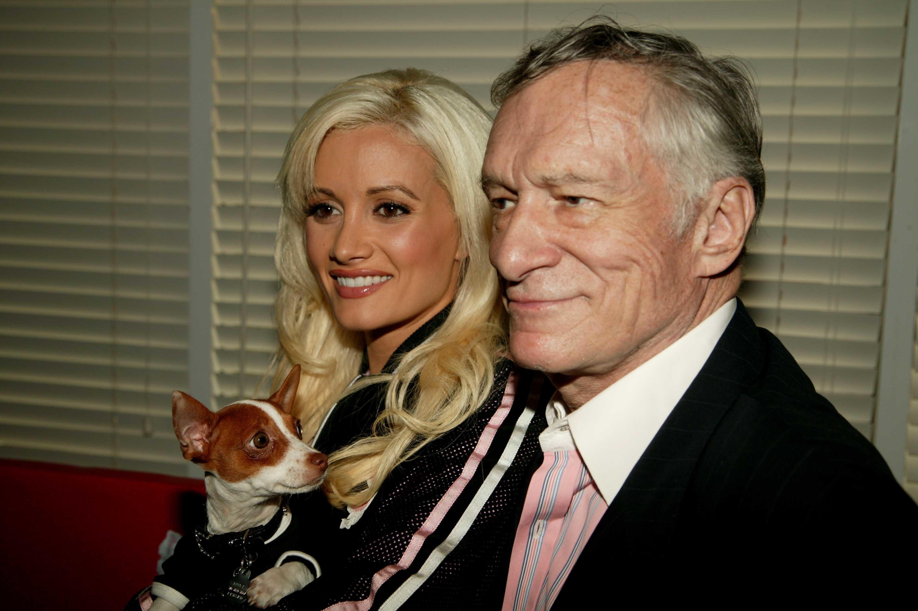 Holly, who is holding a small dog, standing next to Hugh