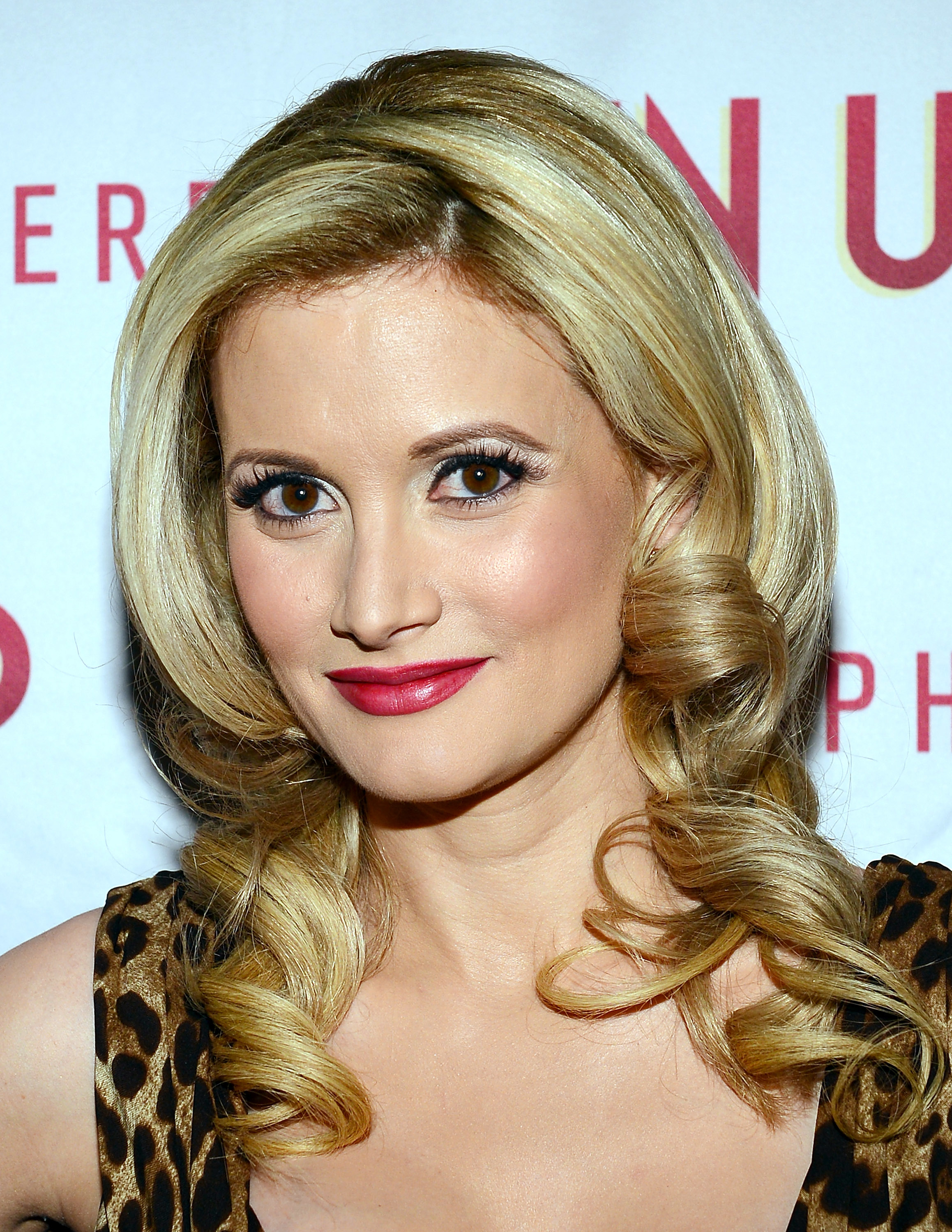 A closeup of Holly wearing red lipstick on the red carpet
