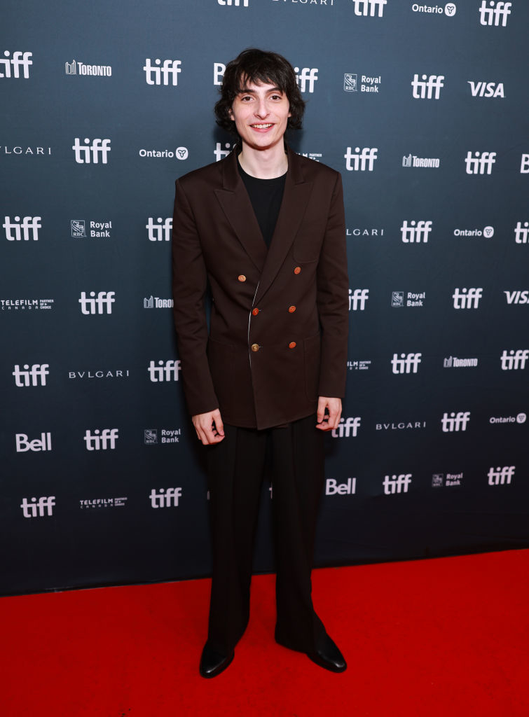 Finn Wolfhard smiles widely on the TIFF red carpet.