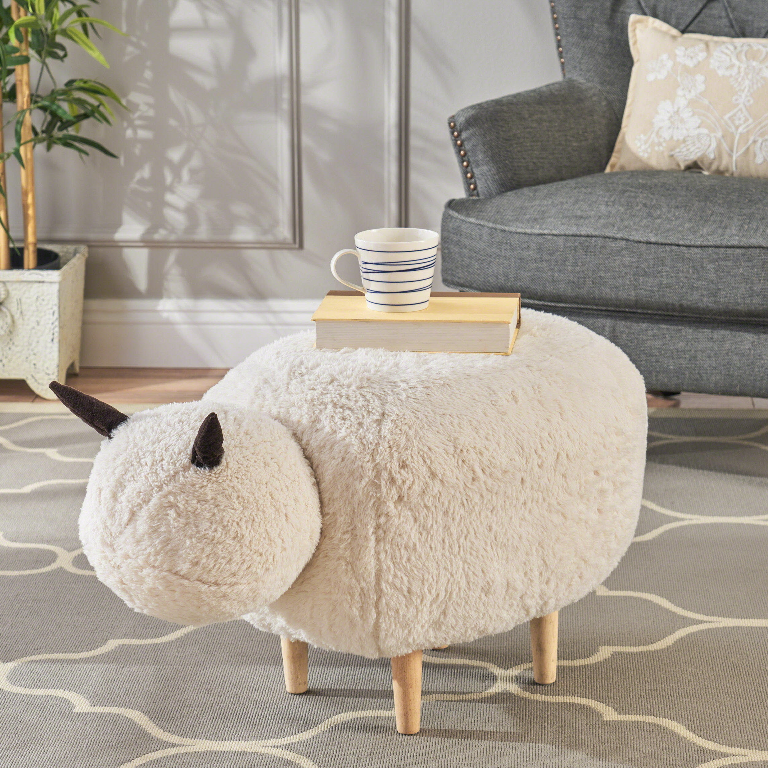 the sheep ottoman with two black ears and wooden legs