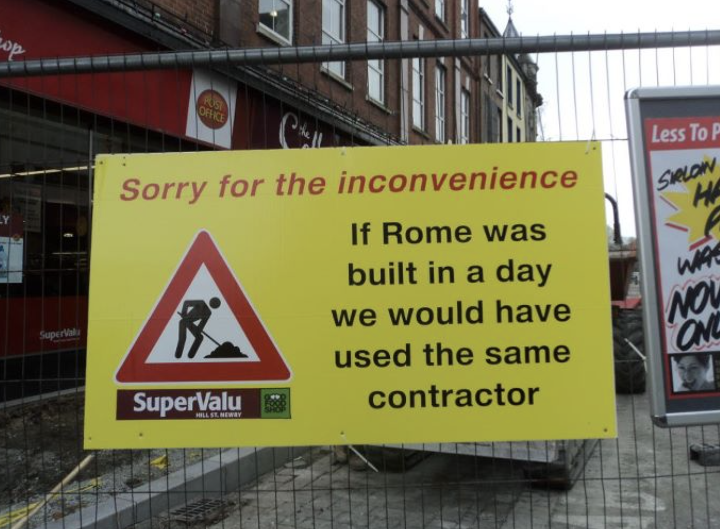 Street construction sign on a gate: &quot;Sorry for the inconvenience: If Rome was built in a day we would have used the same contractor&quot;