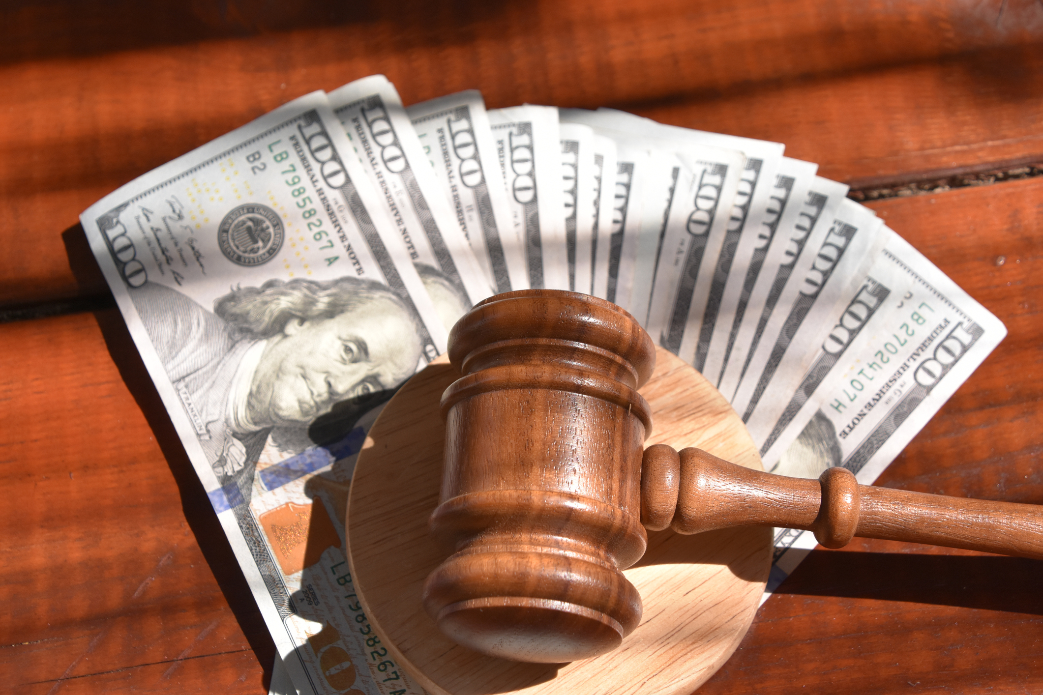 a judge&#x27;s gavel on top of fanned out money