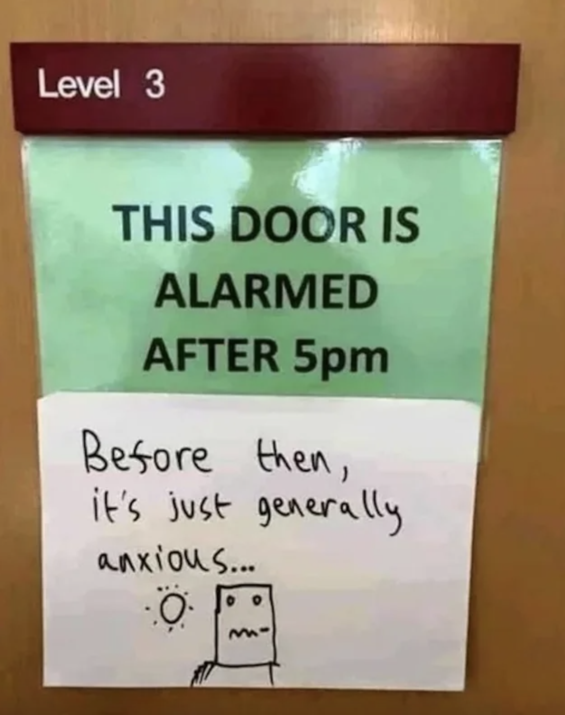 Sign on a door: &quot;This door is alarmed after 5 pm&quot;; handwritten below it: &quot;Before then, it&#x27;s just generally anxious&quot;