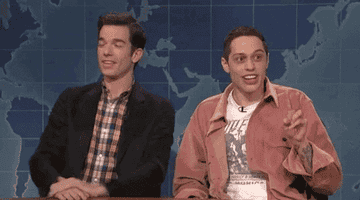 John Mulaney and Pete Davidson sit side by side as Pete shouts &quot;TWO&quot; holding up two fingers.