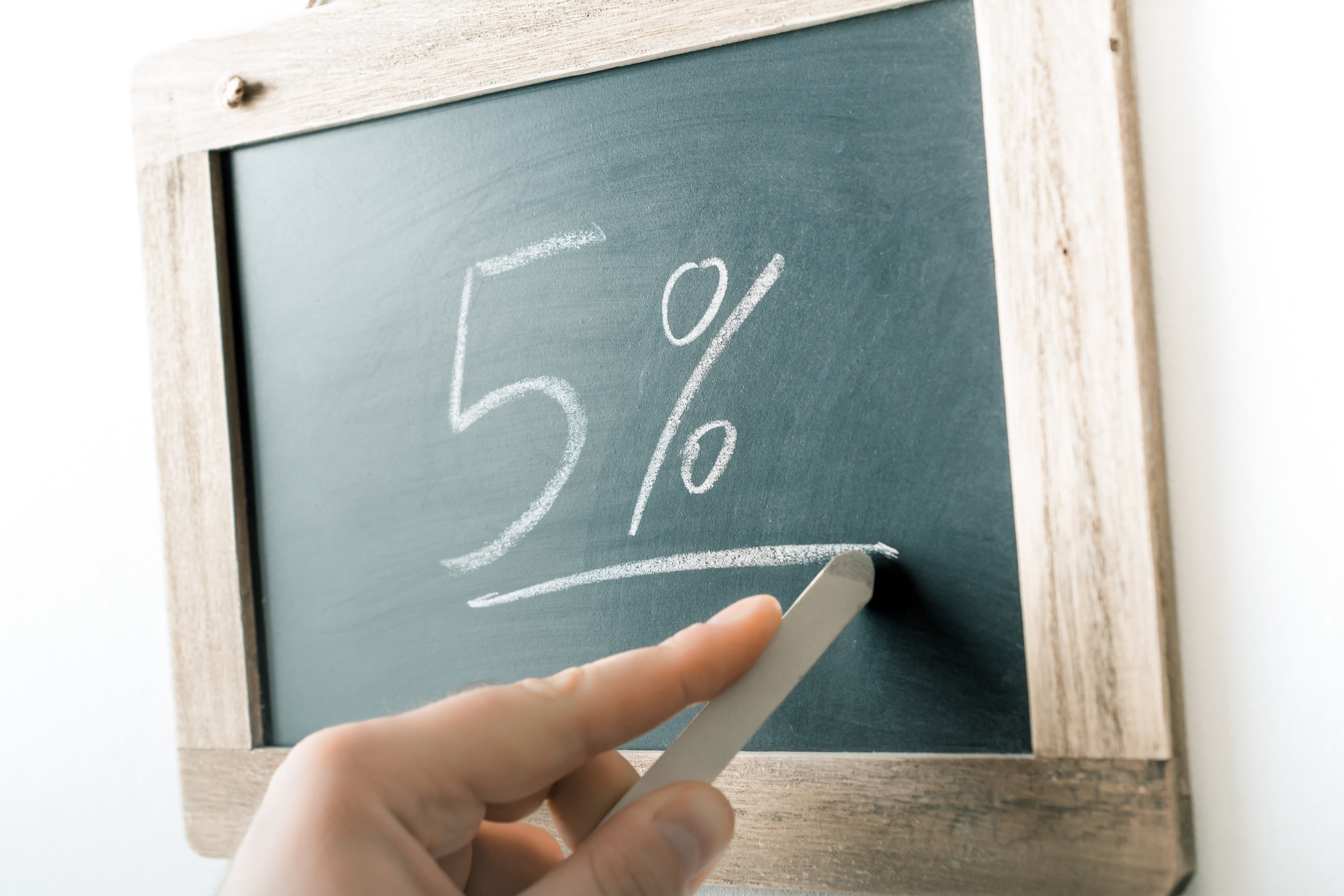 Person writing 5% on a chalkboard