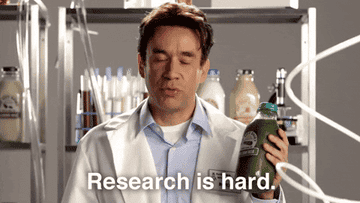 Fred Armisen dressed as a doctor in a white lab coat says &quot;Research is hard.&quot;