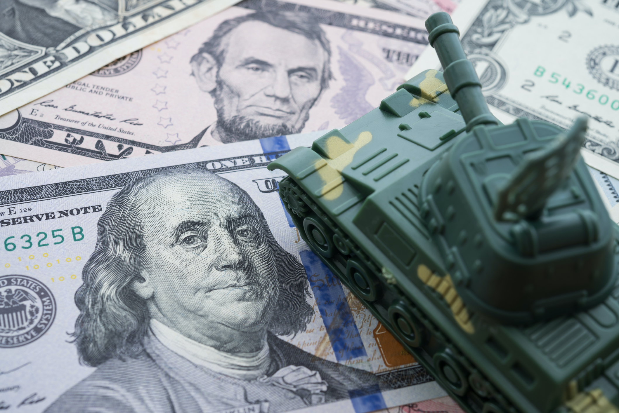 toy tank on top of money