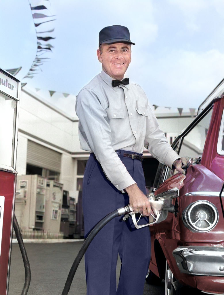 someone pumping gas into an old car