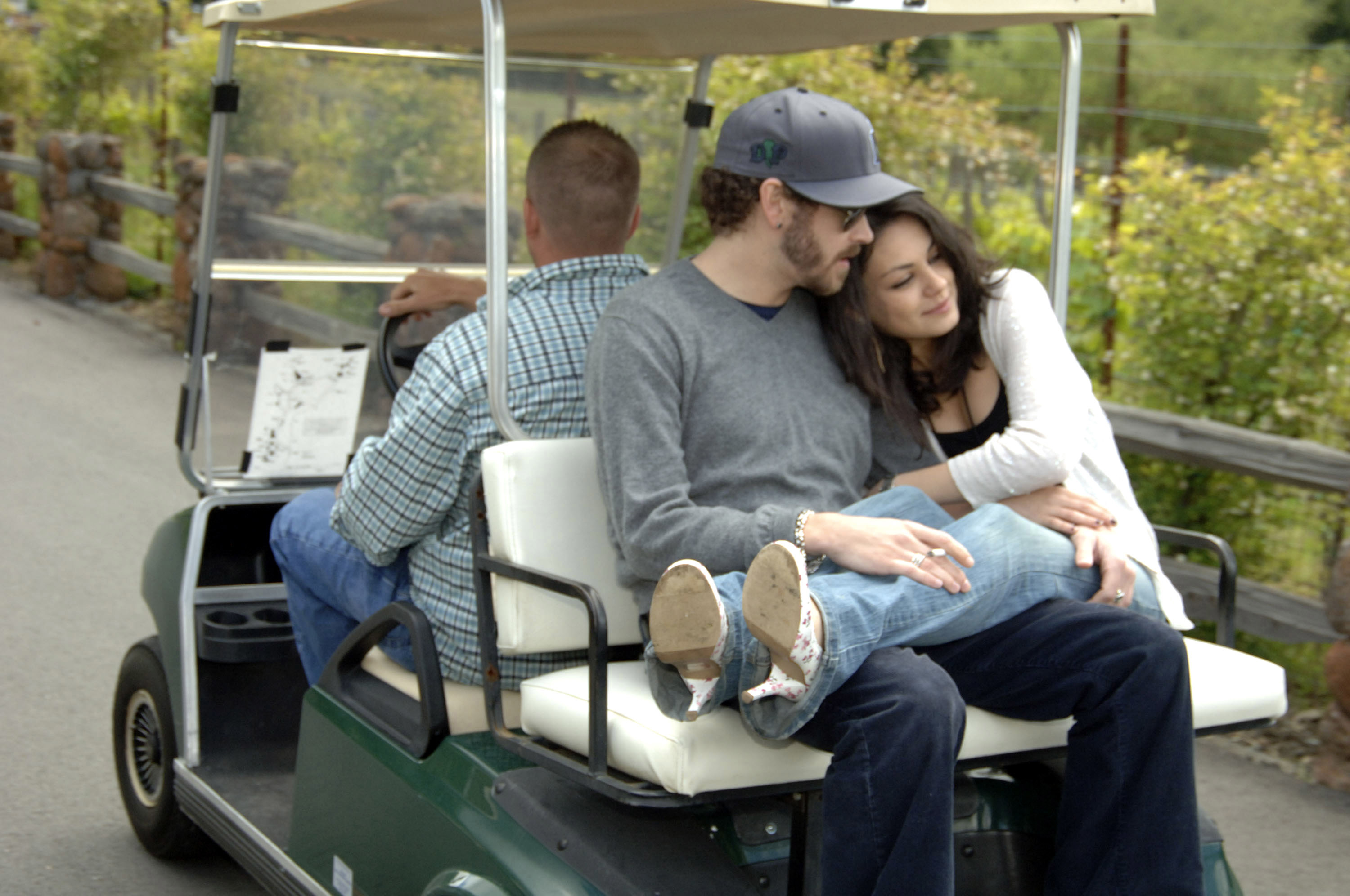 Mila with her legs in Dnny&#x27;s lap as they ride in the back of a golf cart