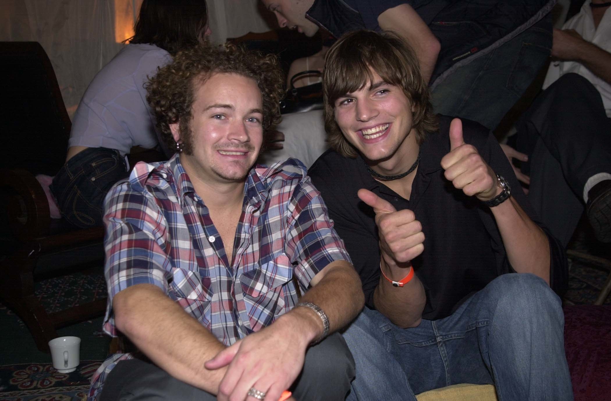 past photo of danny and ashton sitting at a party