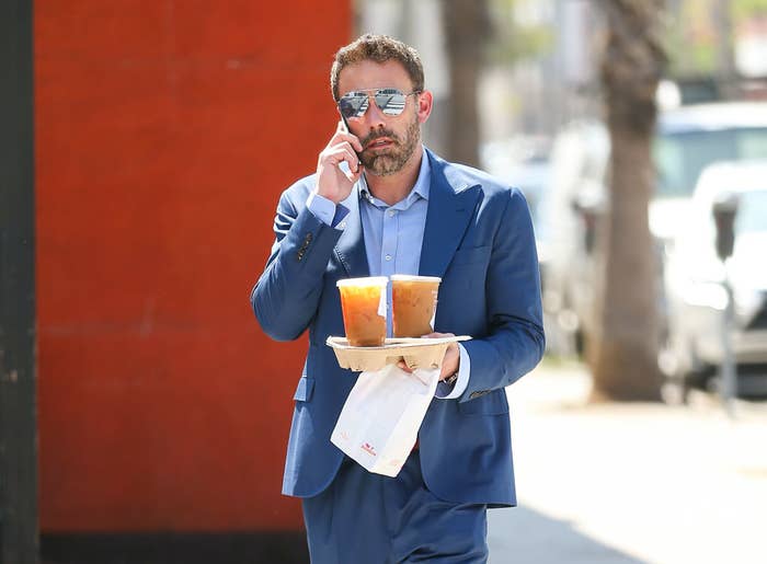 Ben holding Dunkin&#x27; beverages and on his phone