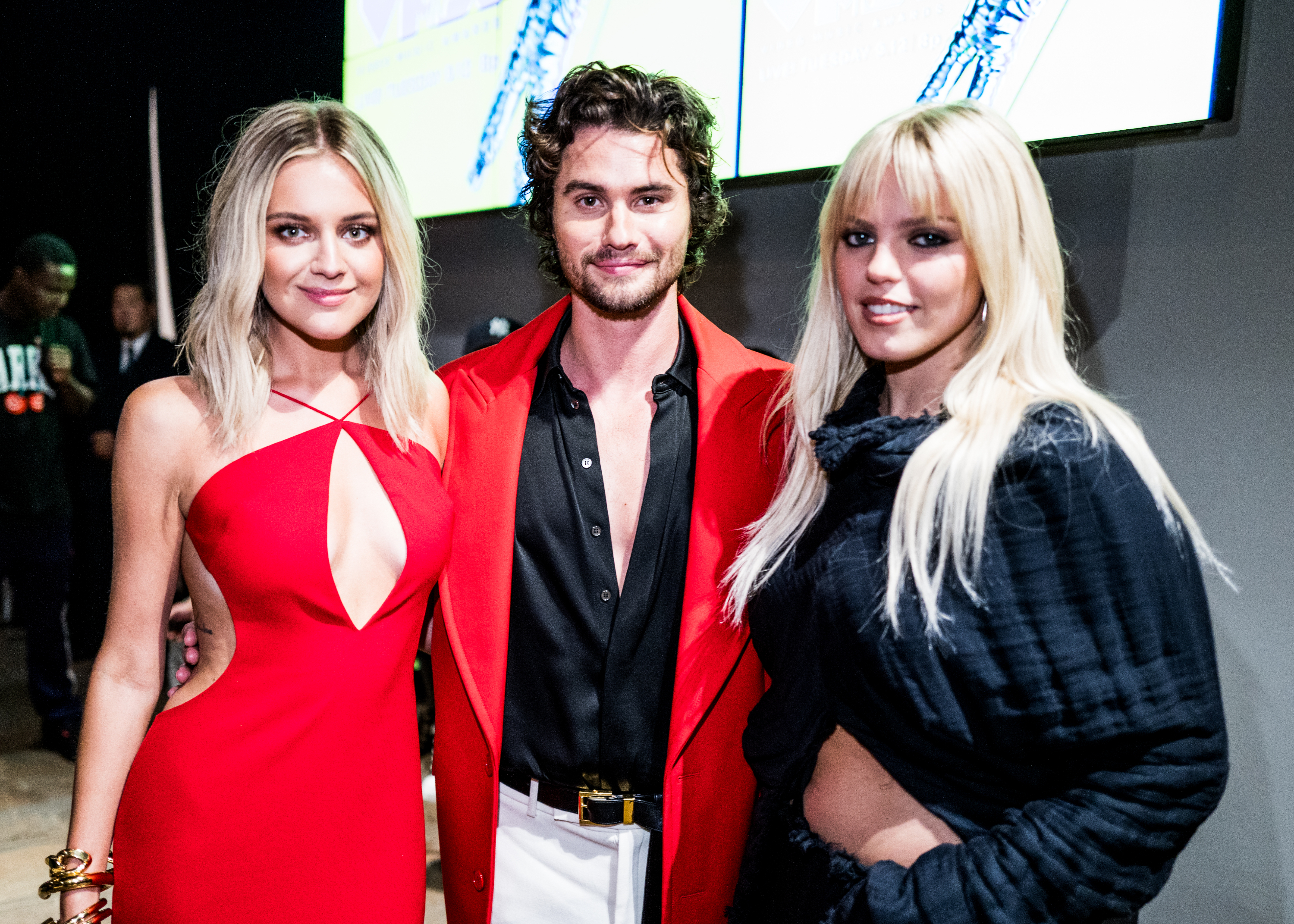 Smiling Kelsea, Chase, and Reneé stand together