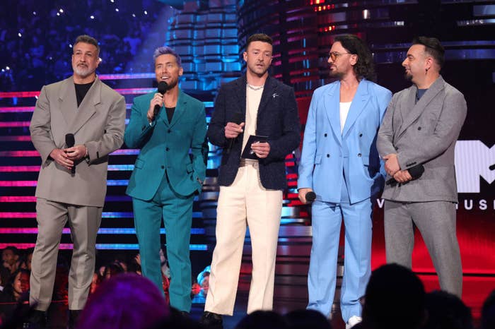 the guys on stage in 2023 with different suits on