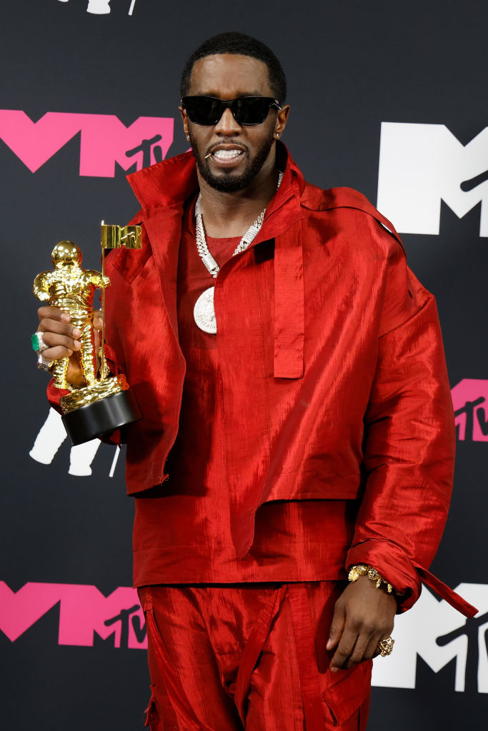 holding his award while wearing an all-red outfit