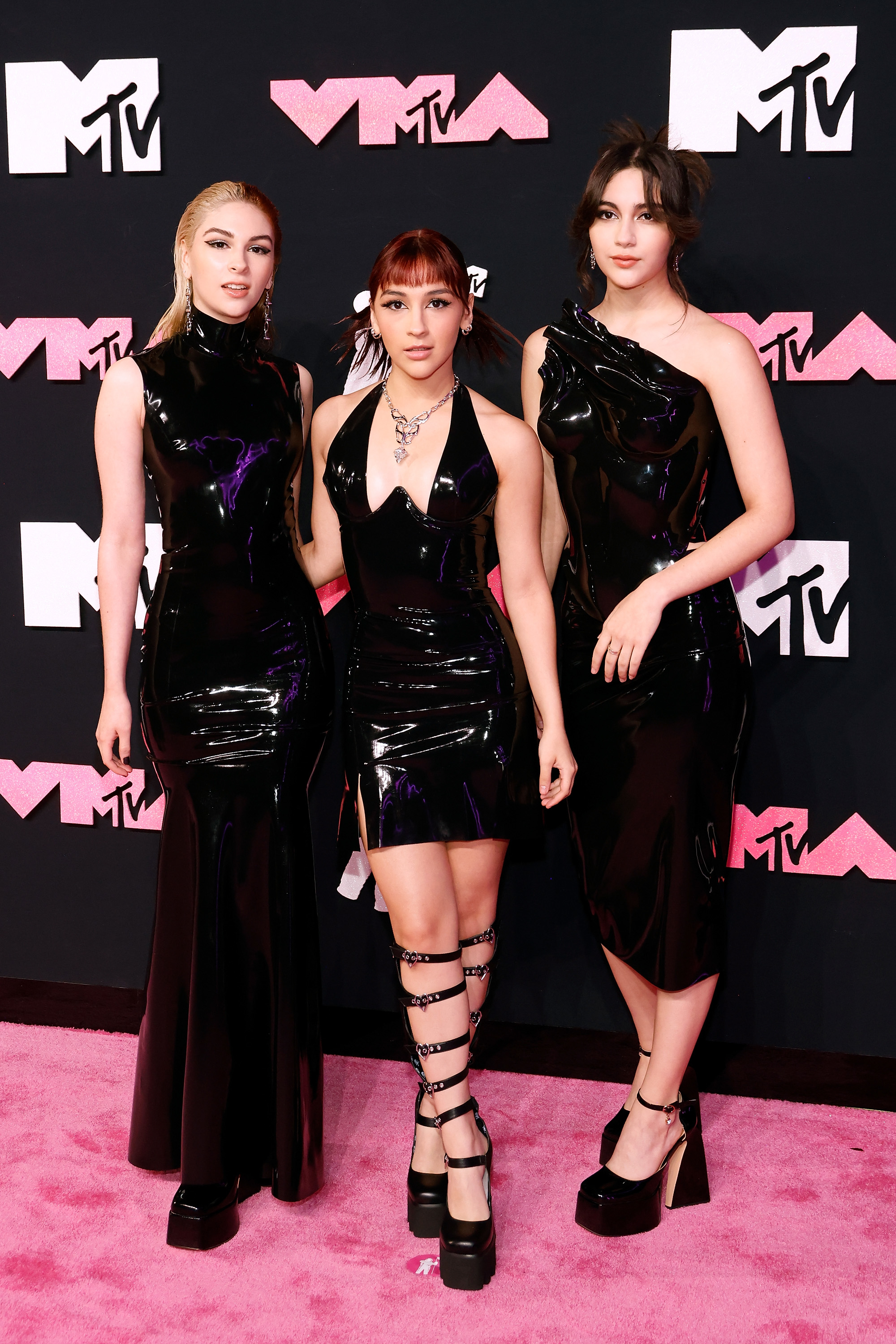 the three in different length dresses that are all tight patent leather