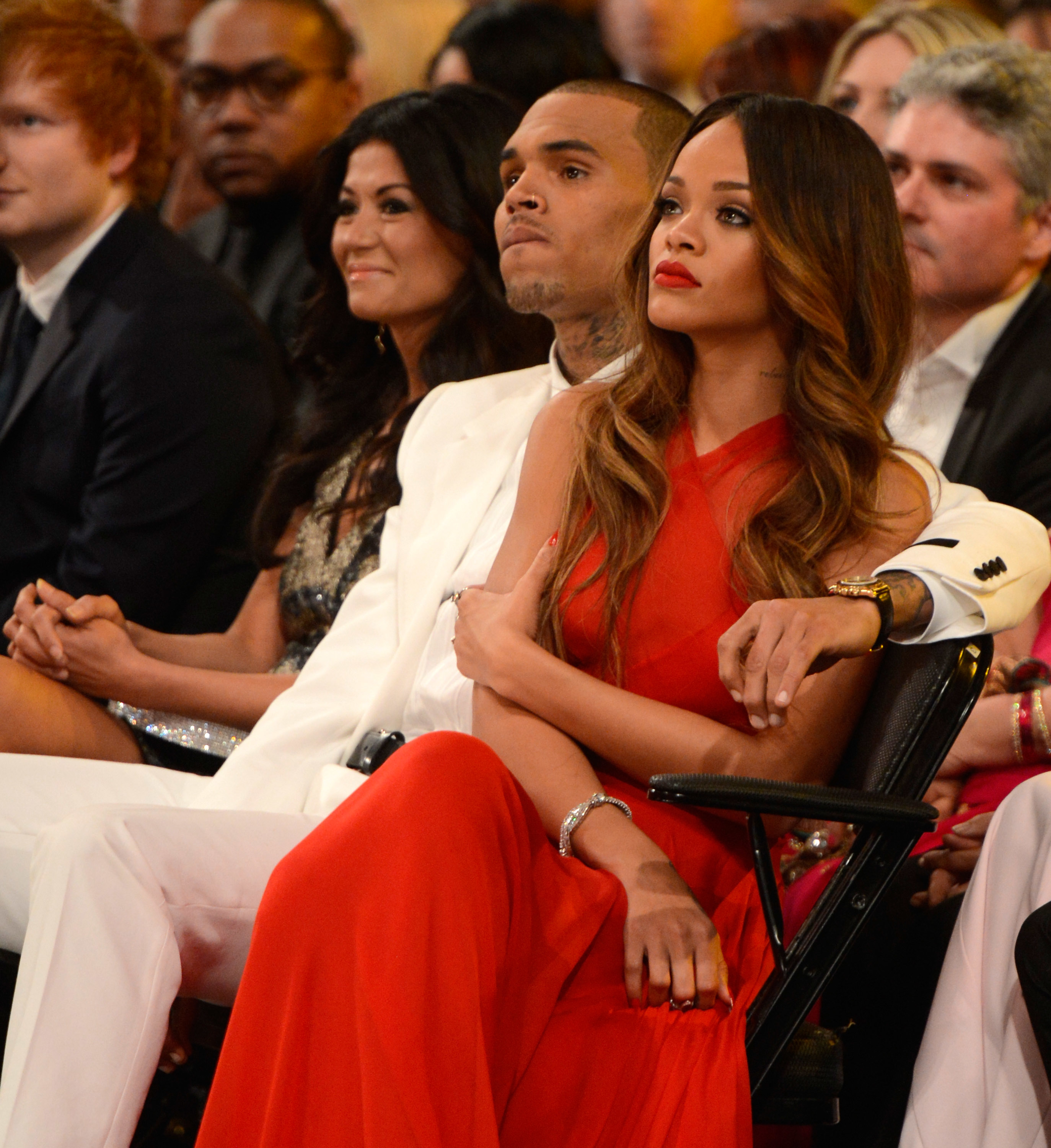 chris brown with his arm around rihanna in the audience