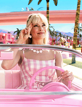 barbie saluting someone in her car