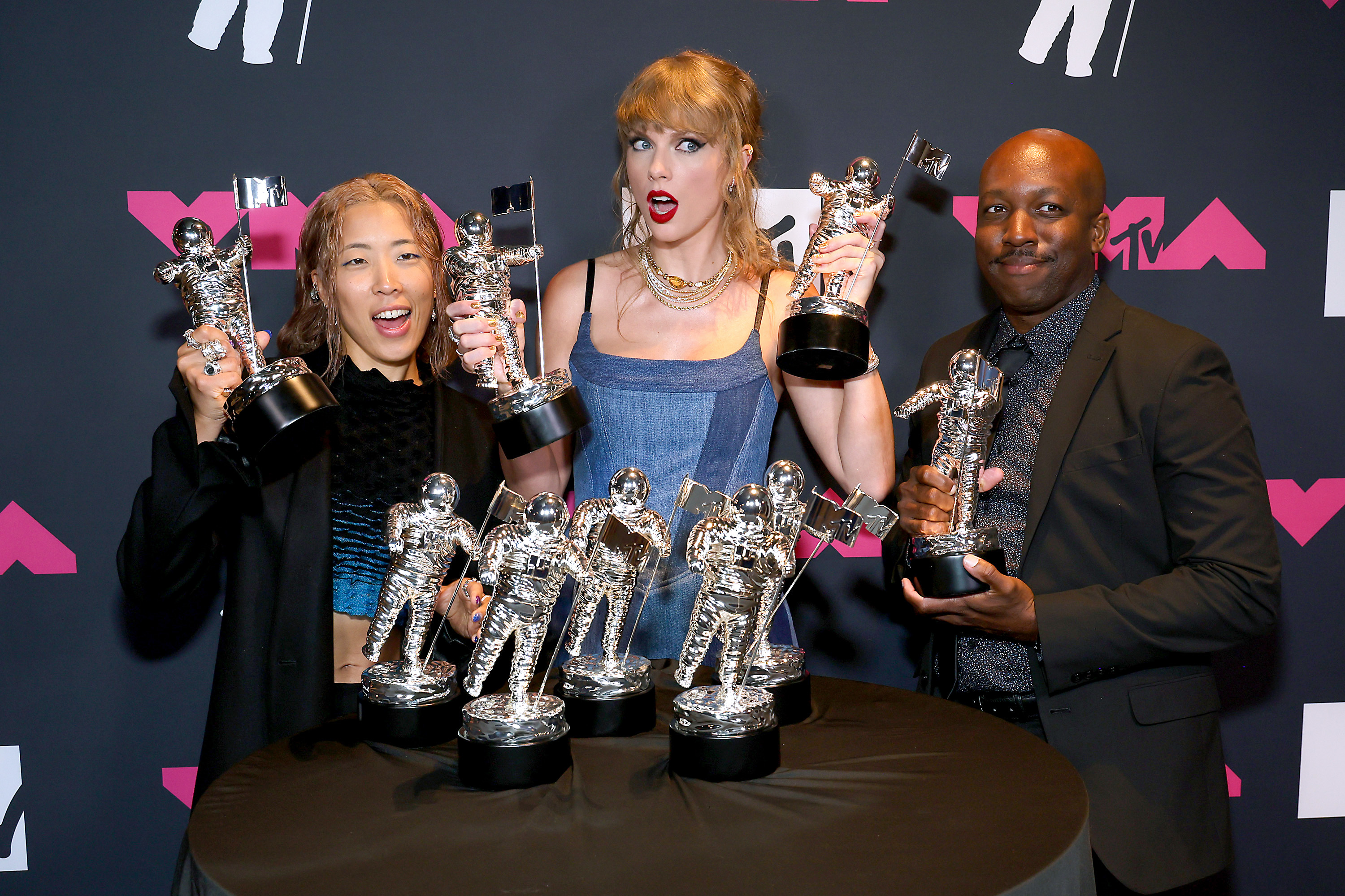 Taylor, Rina, and Chancler hold awards, with five more on a table in front of them