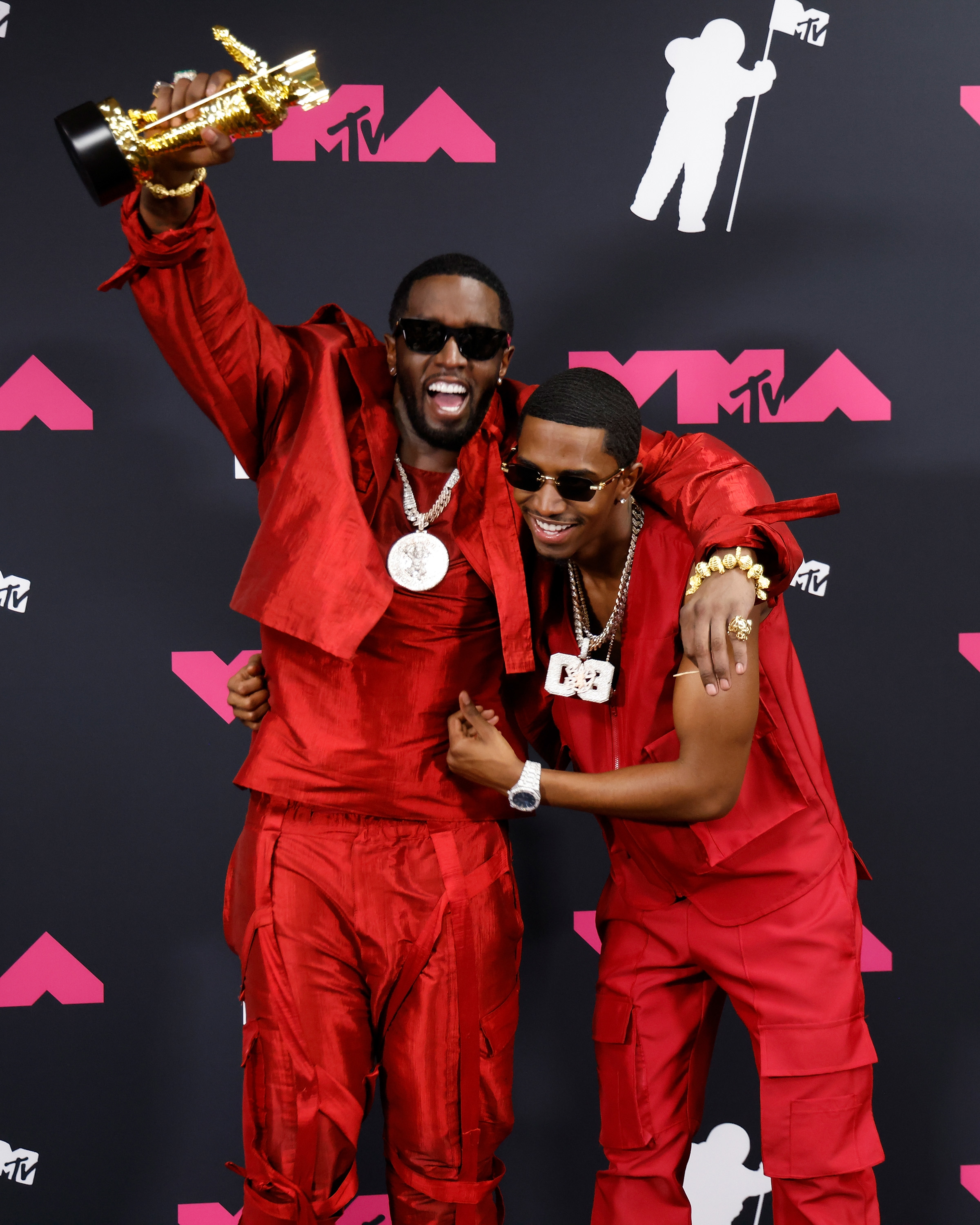 Diddy and Kim, both in red and sunglasses, on the red carpet