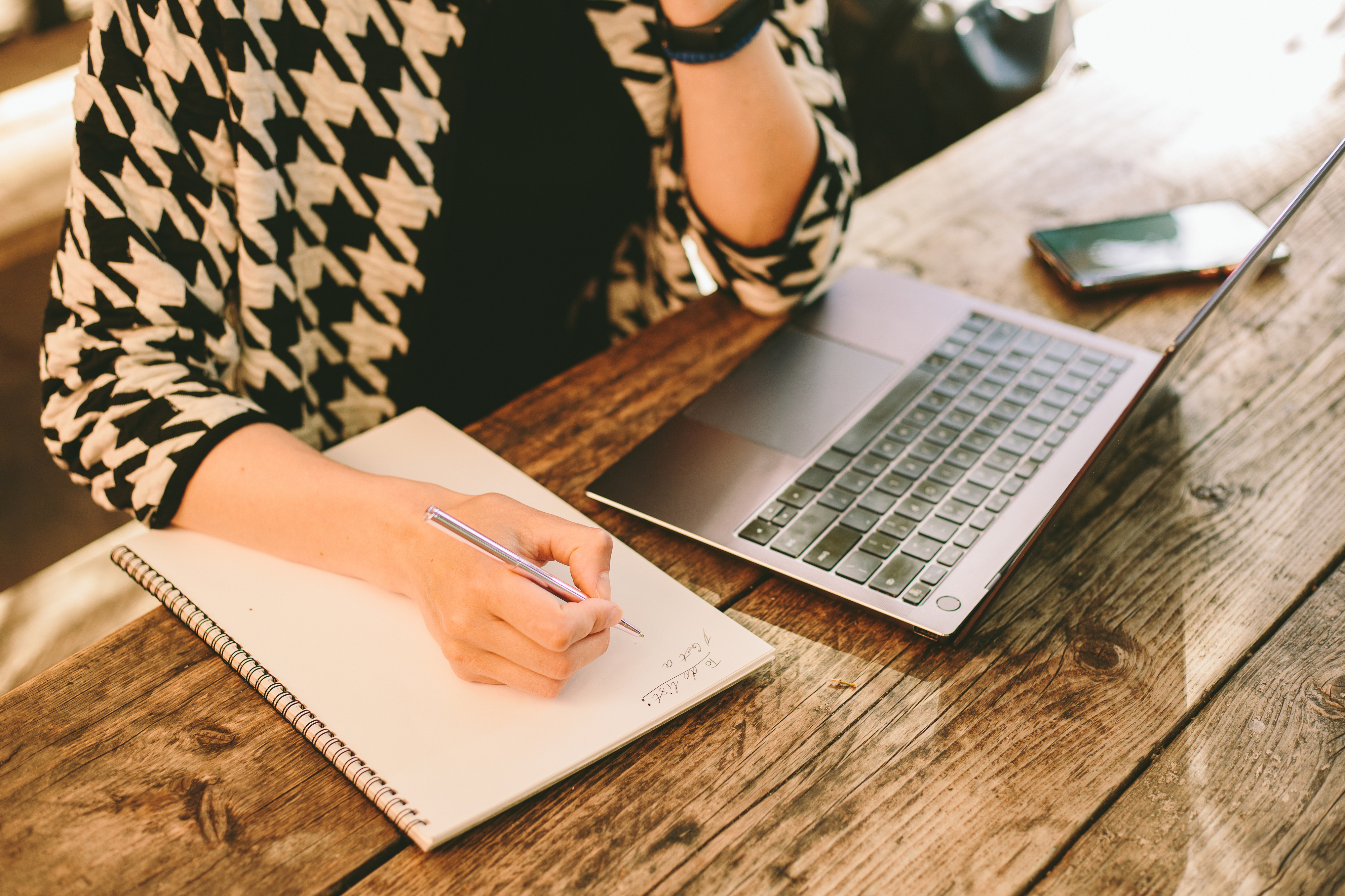 a person writing on a notepad