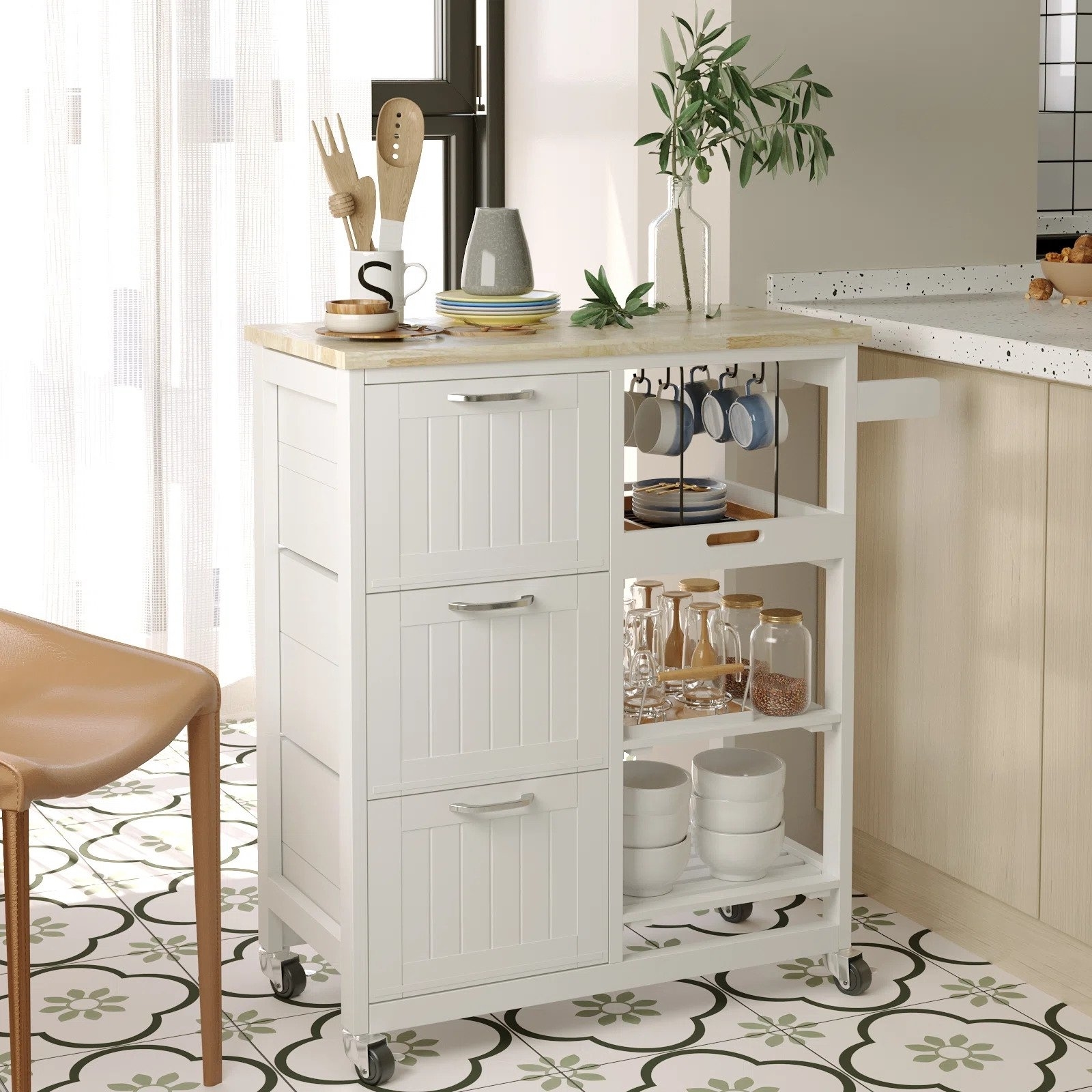 The white kitchen island with a natural wood countertop and silver pulls