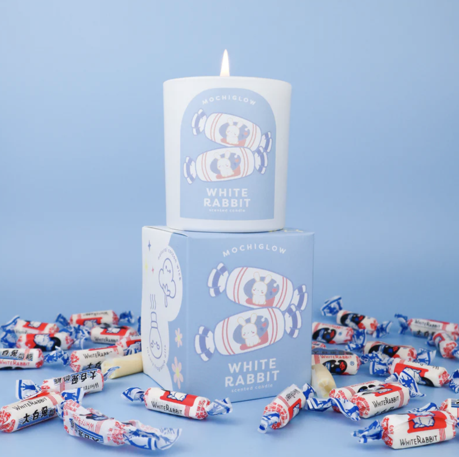 White Rabbit Candy-themed scented candle on top of corresponding box surrounded by White Rabbit Candies