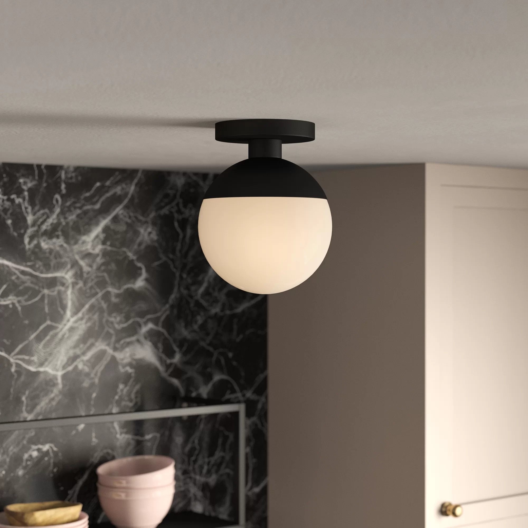 The semi-flush mount light, featuring a matte black metal base and matte glass globe