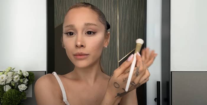 Ariana holding a makeup brush