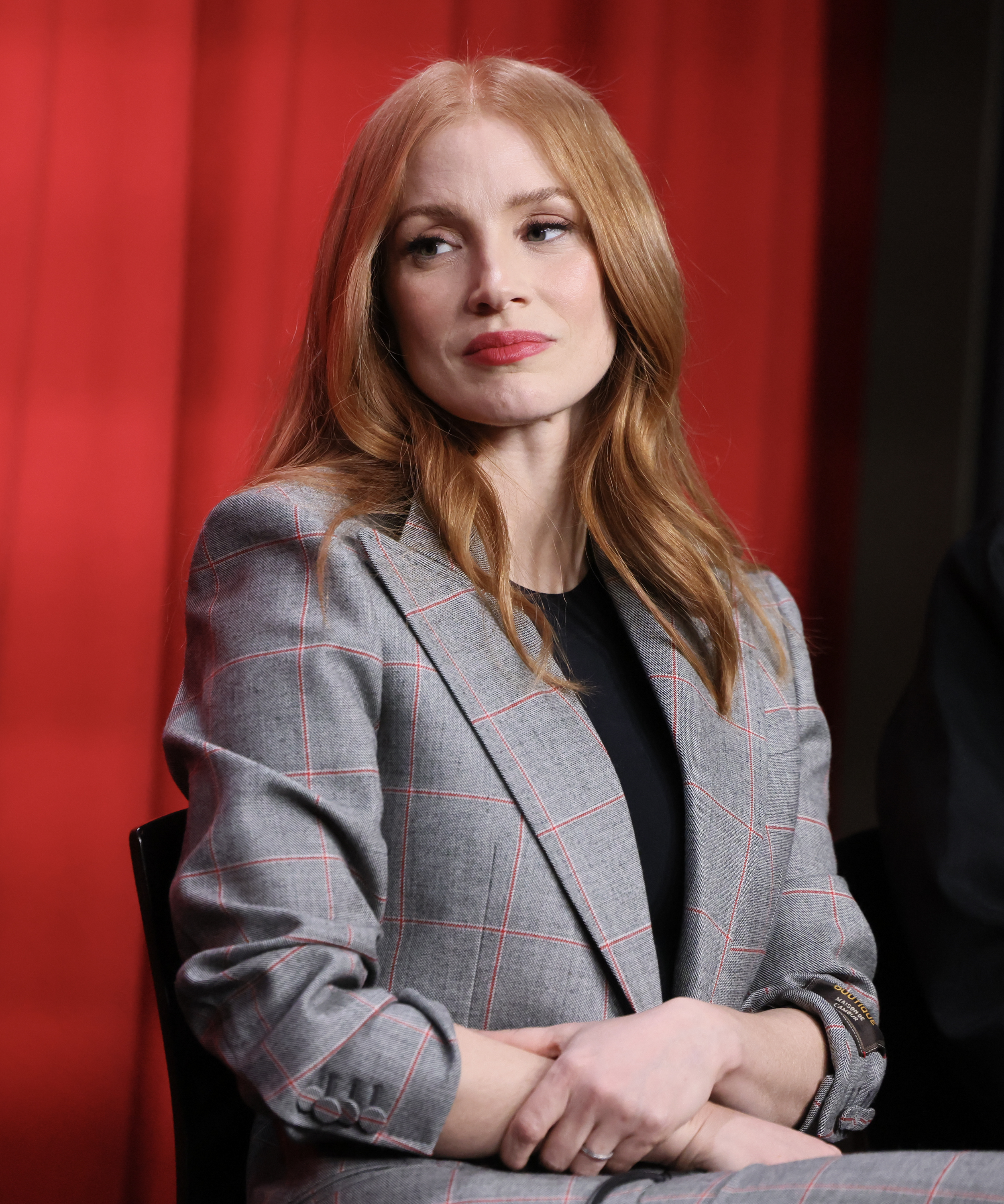 Close-up of Jessica with arms folded and wearing a suit