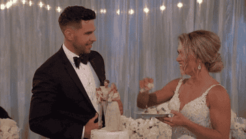 husband and wife smashing cake in face