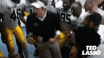 Ted Lasso celebrates with his football team.