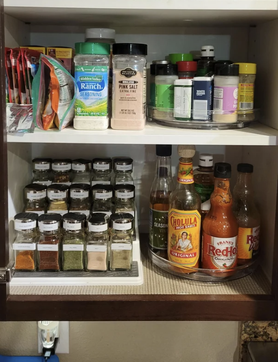 Someone&#x27;s spice cabinet featuring two spice racks and a sauce rack