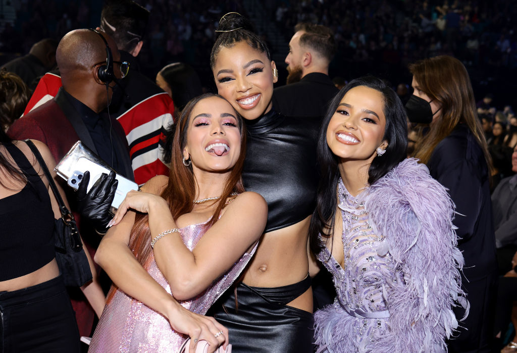 Anitta, Chloe, and Becky G smiling and embracing
