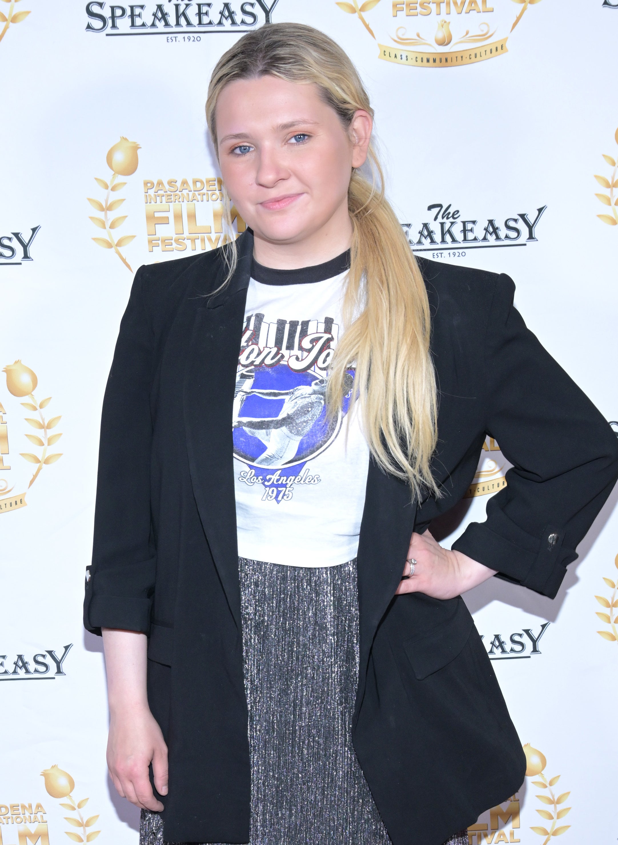 Abigail in a long suit jacket and graphic T-shirt