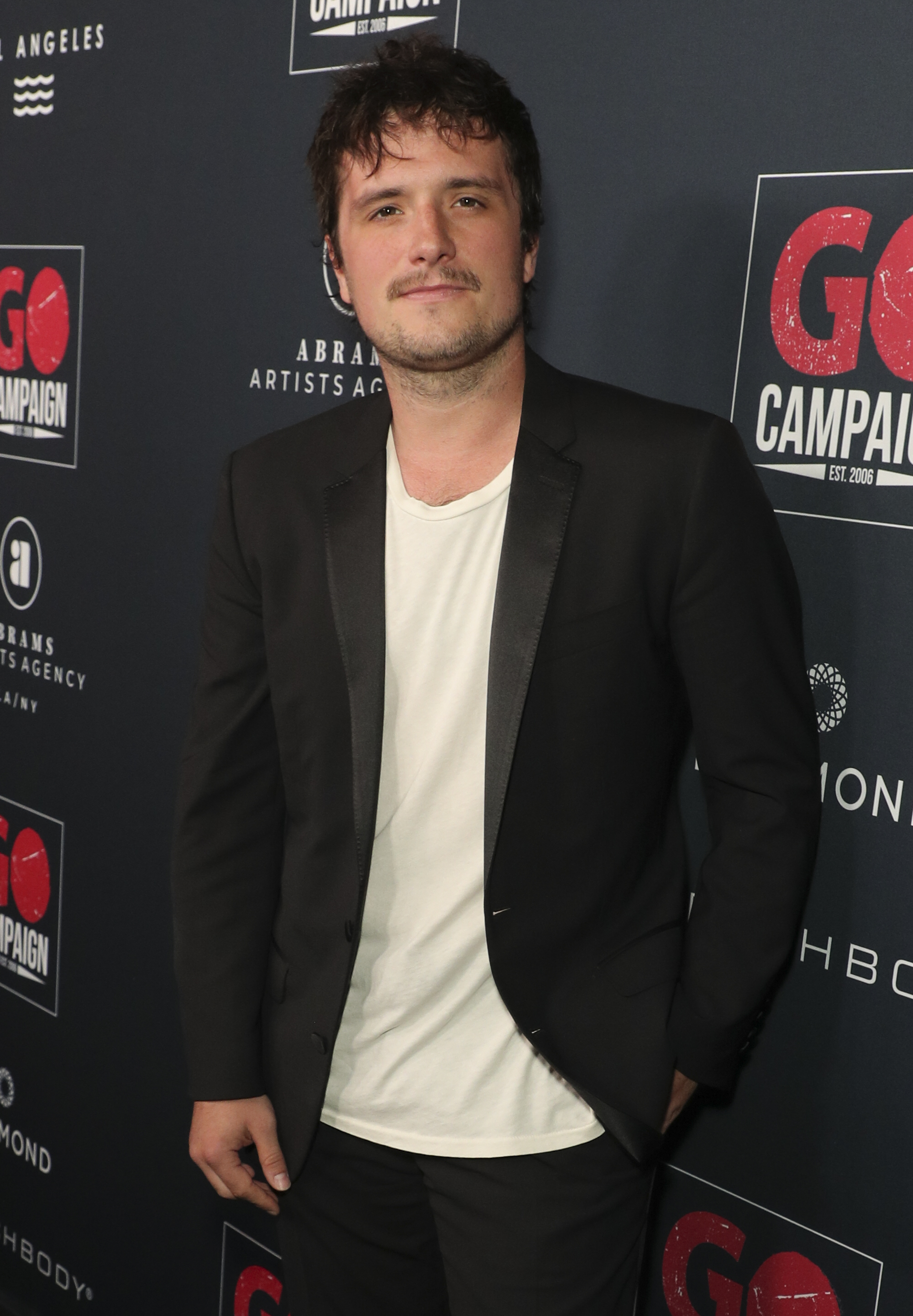 Josh in a suit jacket, T-shirt, and pants
