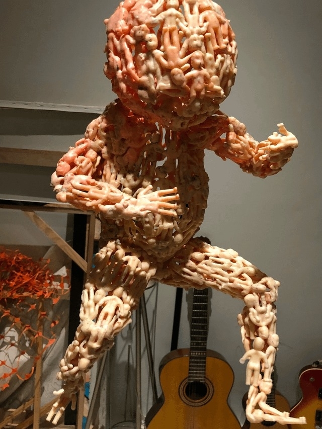 sculpture of a standing baby made of tiny babies
